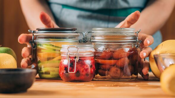 Woman with jars of fermented fruit.