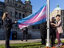 BC government employees raise the transgender flag at the legislature on Thursday, March 30.